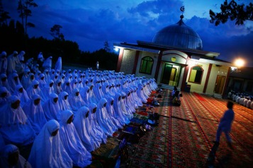 Muslim worshippers gather for an evening collective prayer and zikr outside a mosque in Banda Aceh